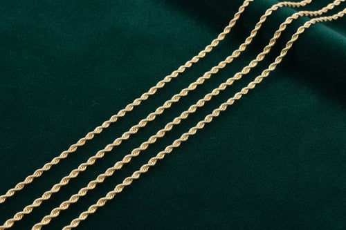 Gold rope chain on a dark green fabric background