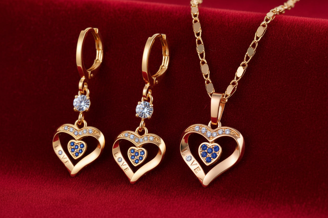 Gold heart-shaped jewelry set with blue stones on a white background, featuring the brand 'HD'.
