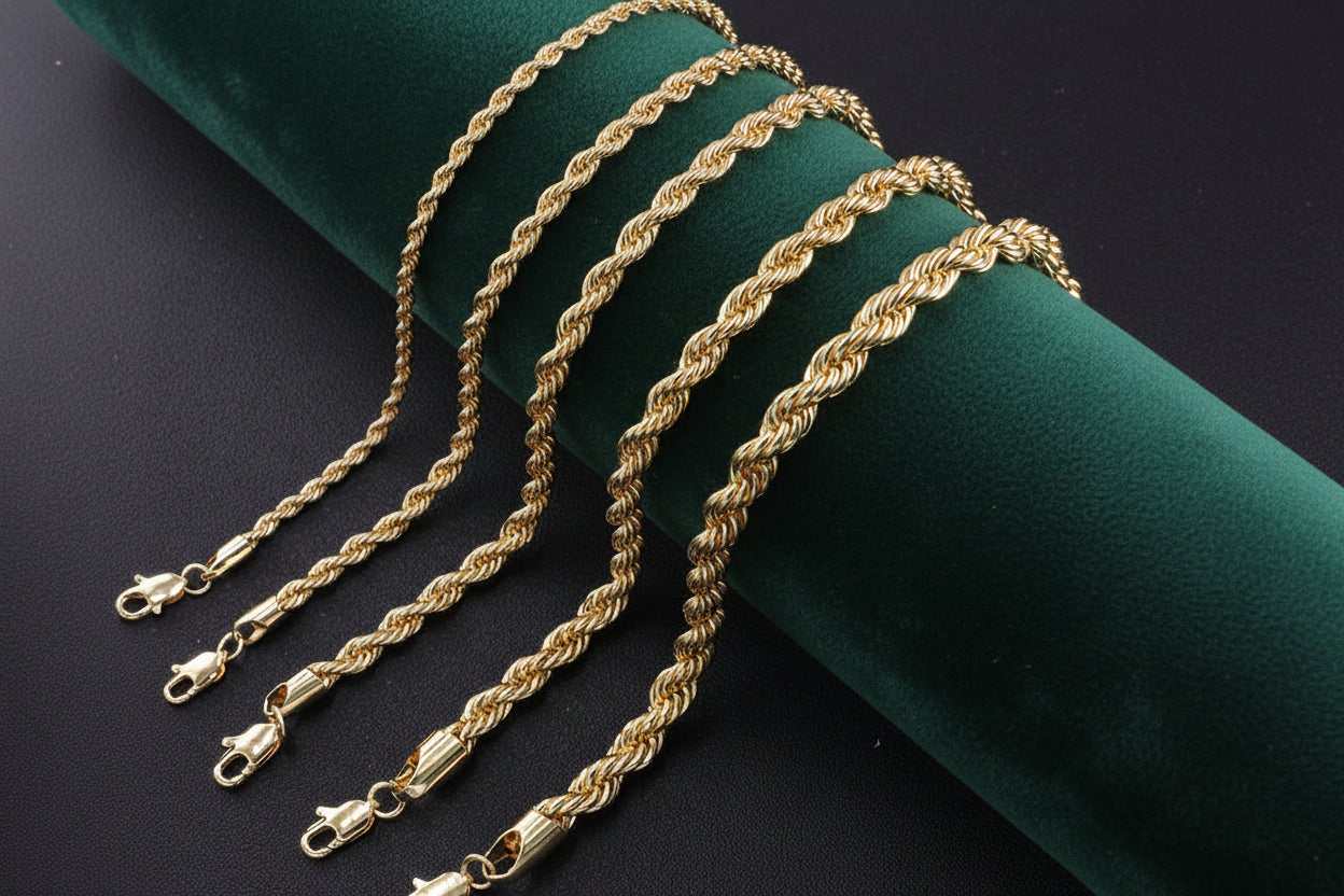 Gold rope chain necklace on a green velvet cushion with a dark background