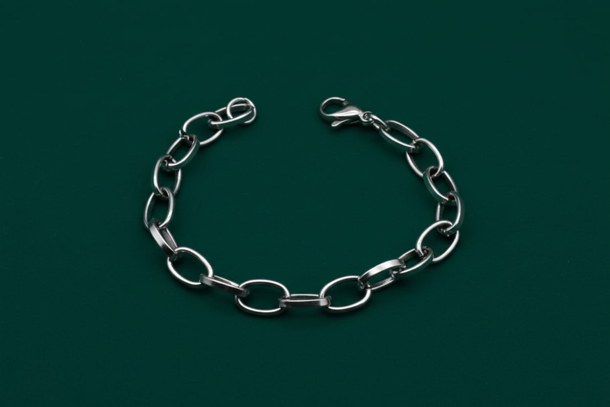 Silver chain bracelet on a black textured background with text about chain width.