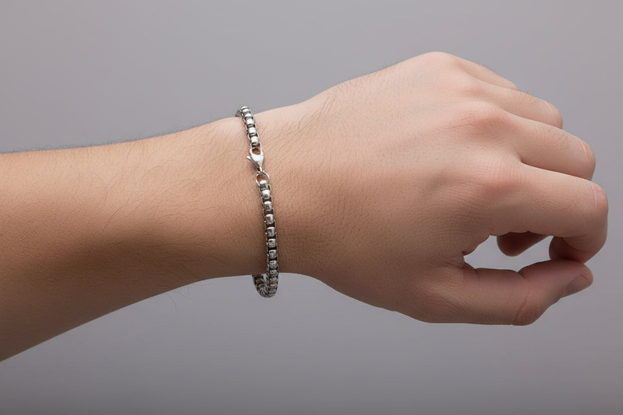 Silver chain bracelet on a green background