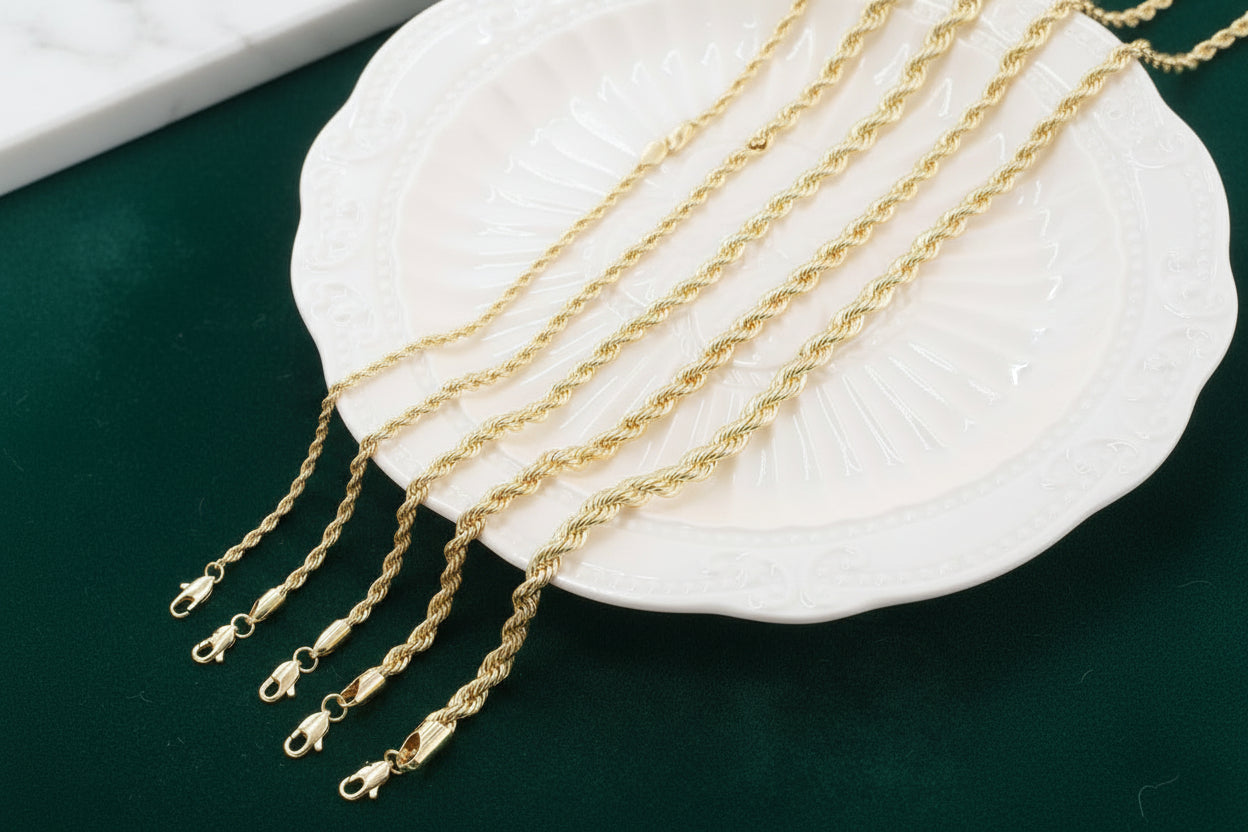 Gold chains displayed on a white shell against a dark green background