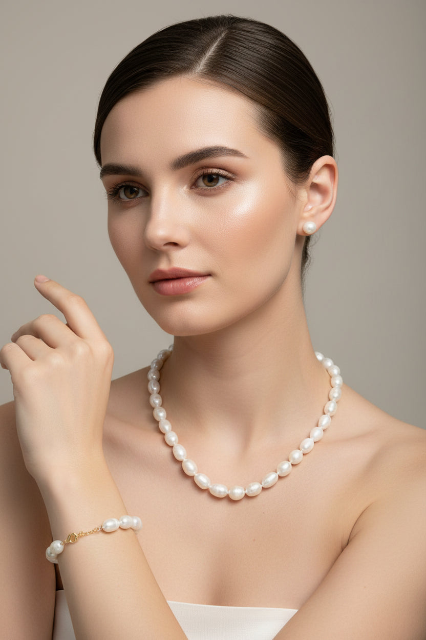Pearl necklace and earrings set on a textured surface