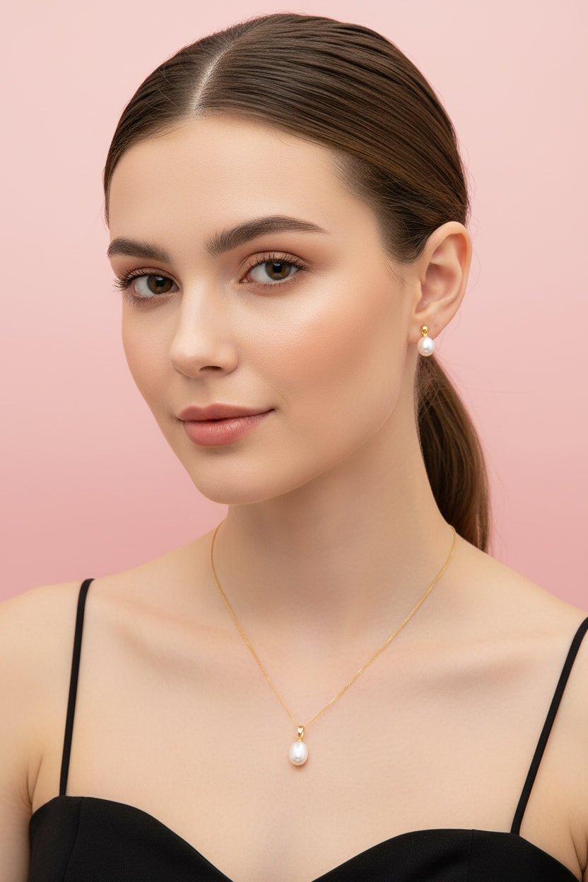 Gold necklace with a pendant and gold earrings on a red background
