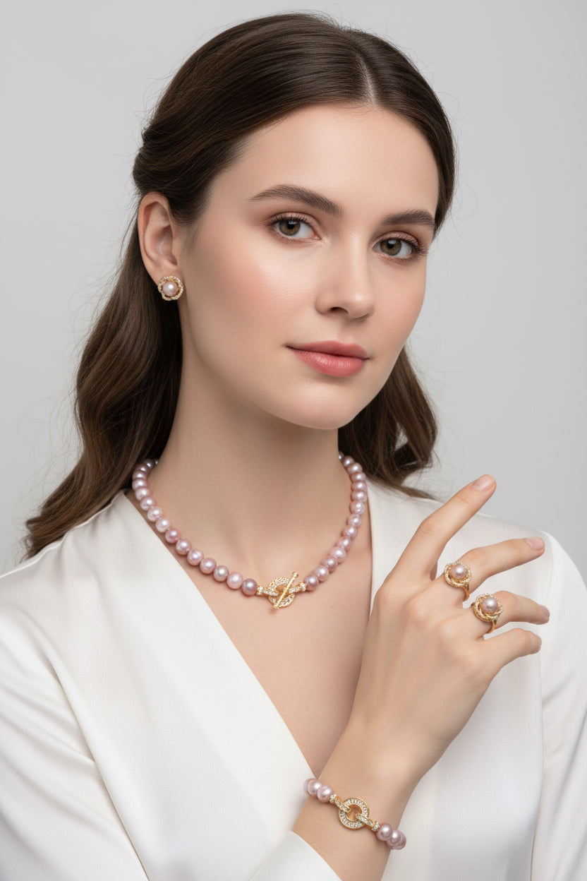 Pearl jewelry set with necklace, bracelet, ring, and earrings on a white background