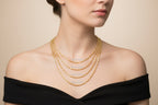 Gold chains of different widths and lengths on a dark blue background
