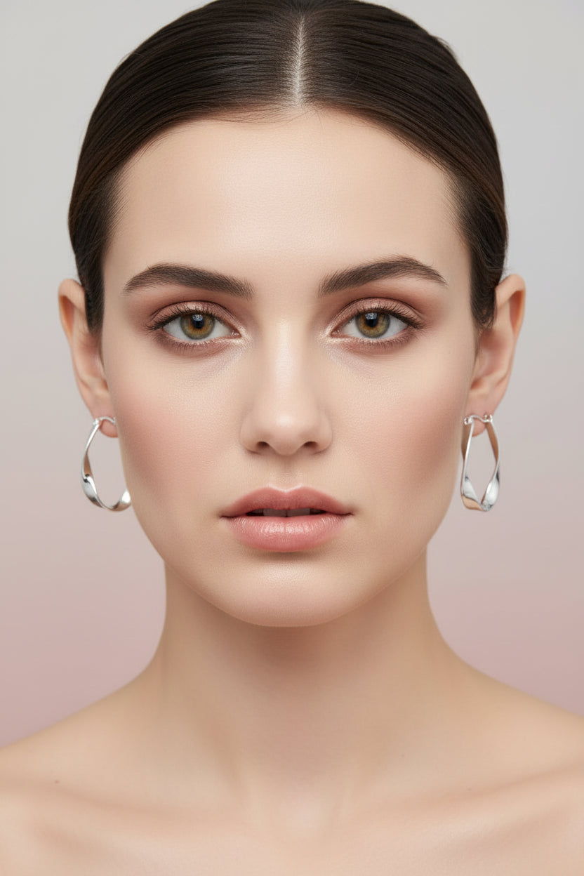Silver hoop earrings on a textured gray surface