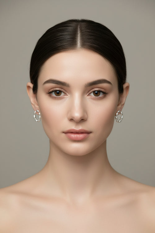 Silver hoop earrings on a reflective surface