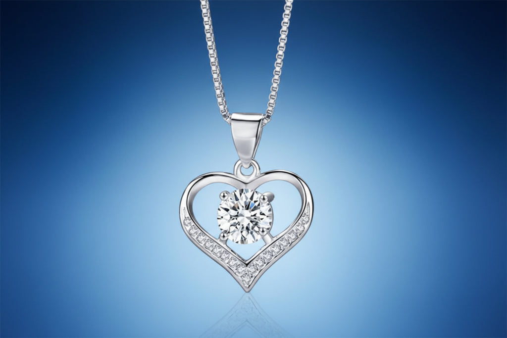 Silver heart-shaped pendant with a central gemstone on a dark textured background