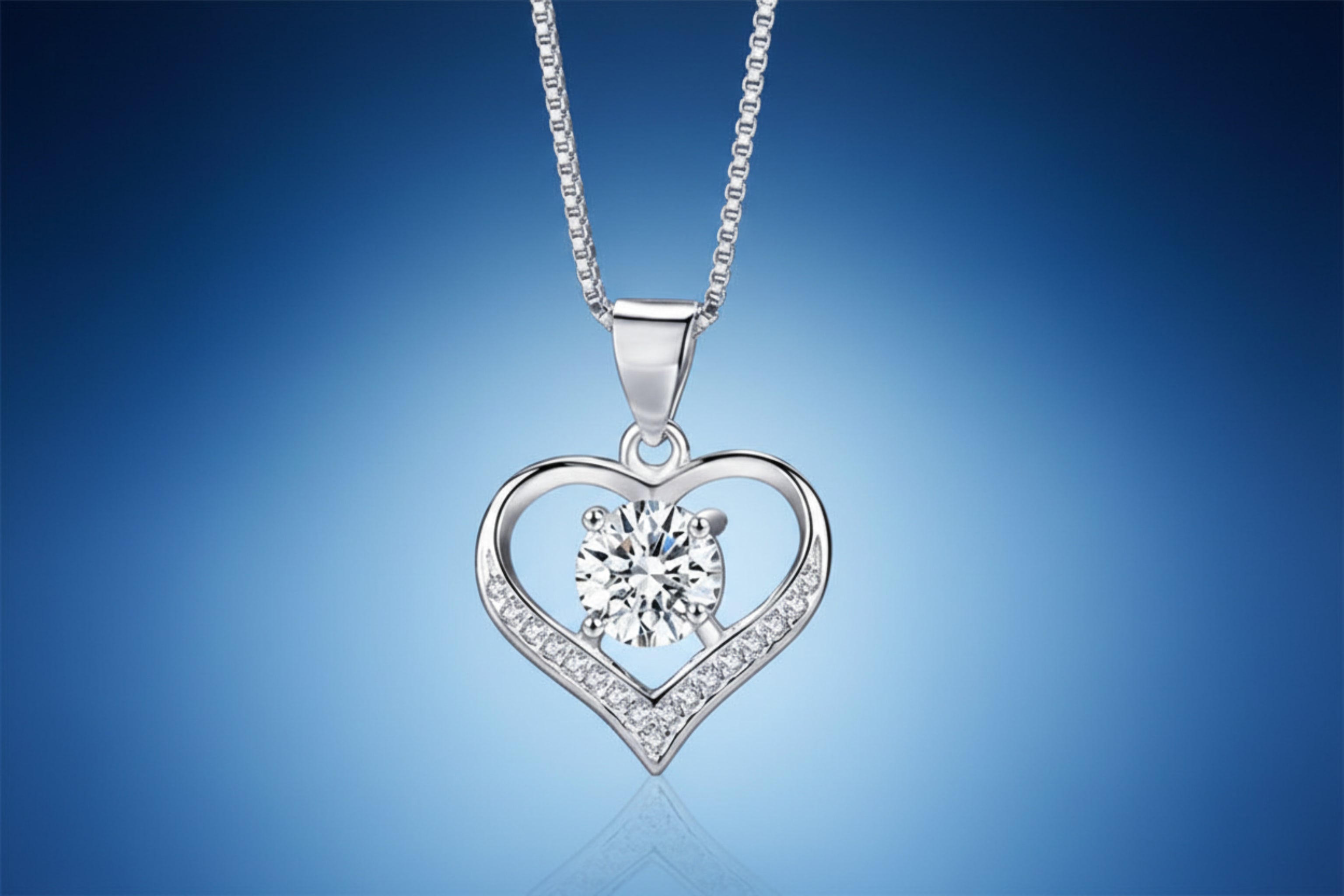 Silver heart-shaped pendant with a central gemstone on a dark textured background