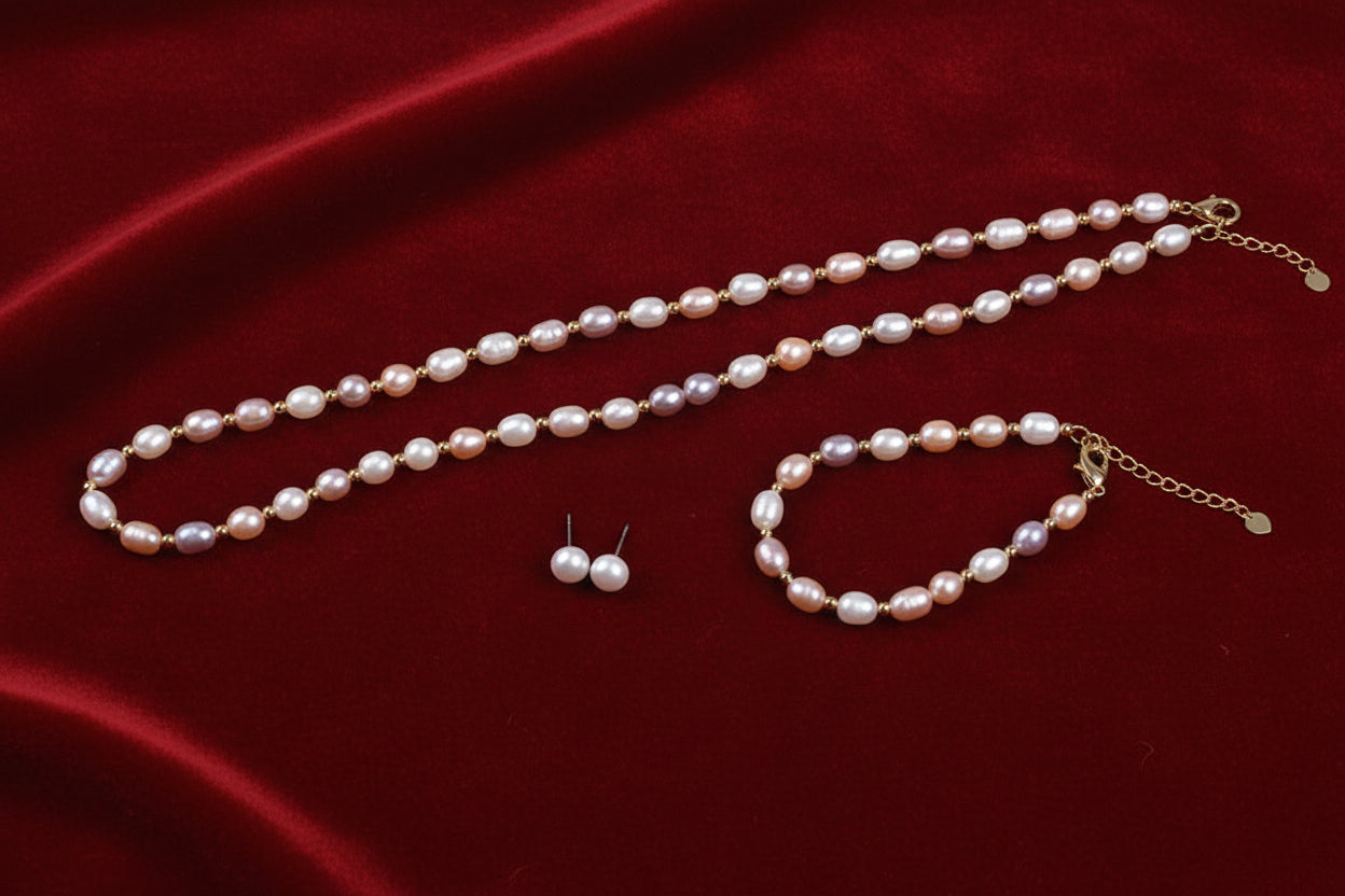 Pearl necklace, bracelet, and earrings on a light gray background