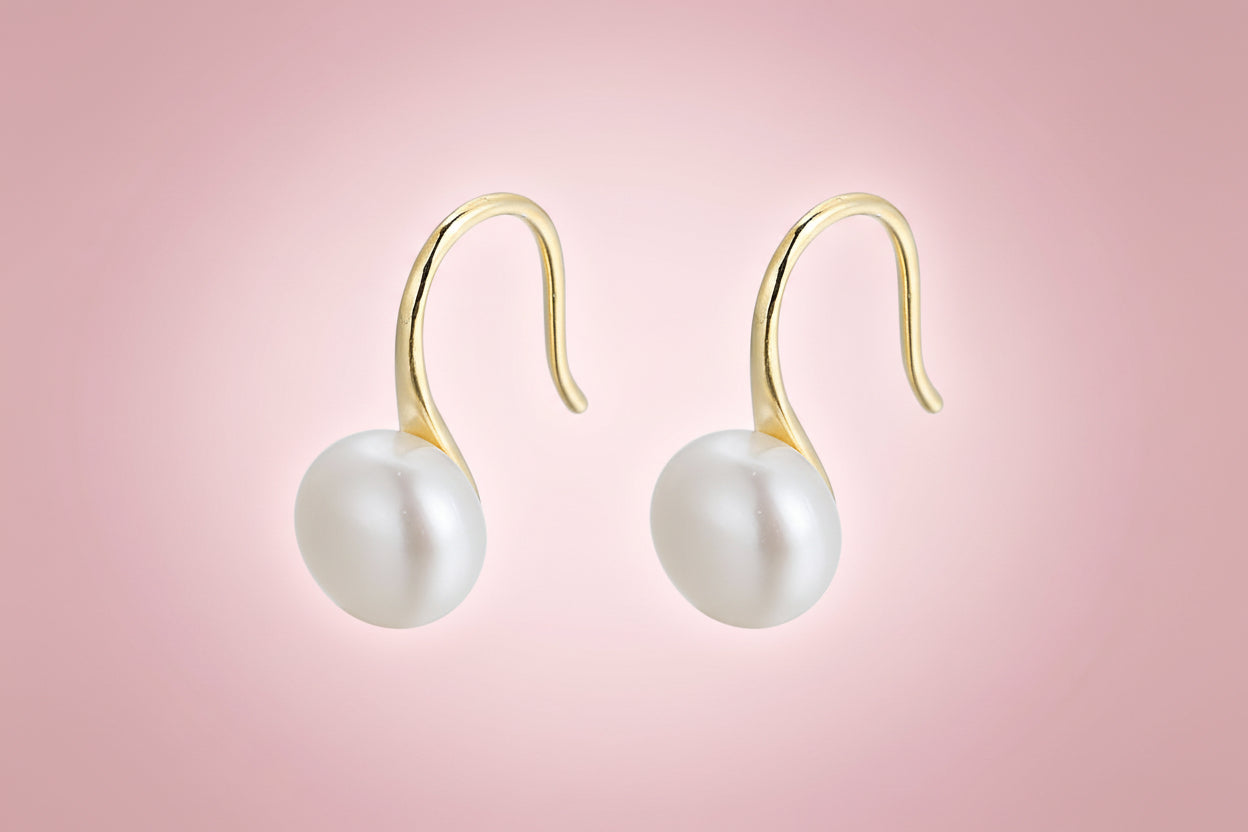 Pearl earrings with gold hooks on a white background