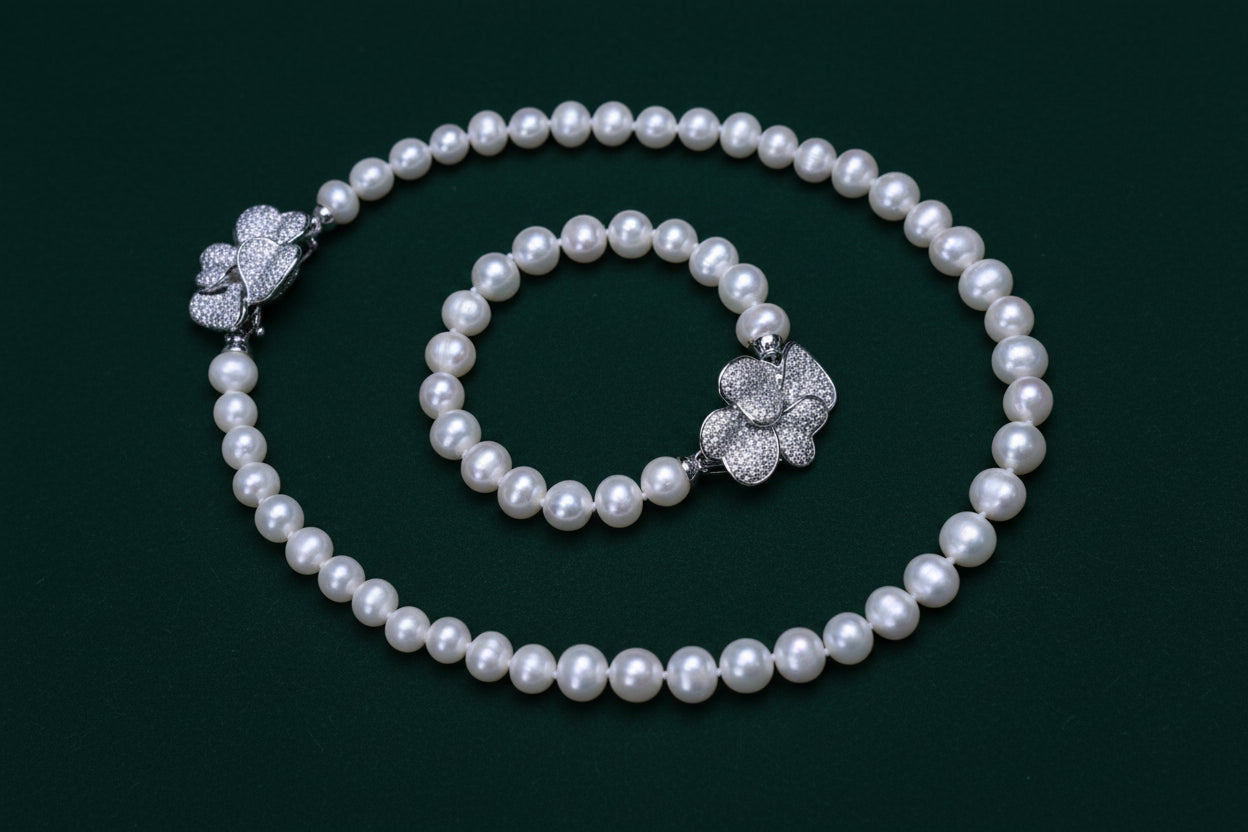 Pearl bracelet with silver flower clasp on a white background