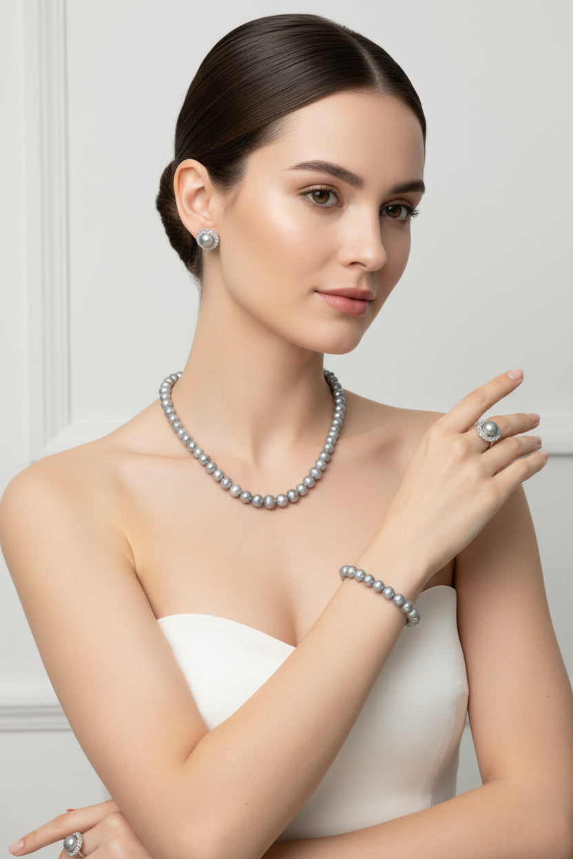 Pearl jewelry set including necklace, bracelet, earrings, and ring in a jewelry box.