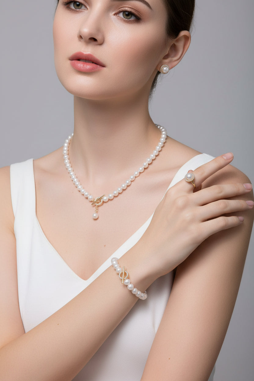 Pearl jewelry set including necklace, earrings, and ring in a jewelry box.