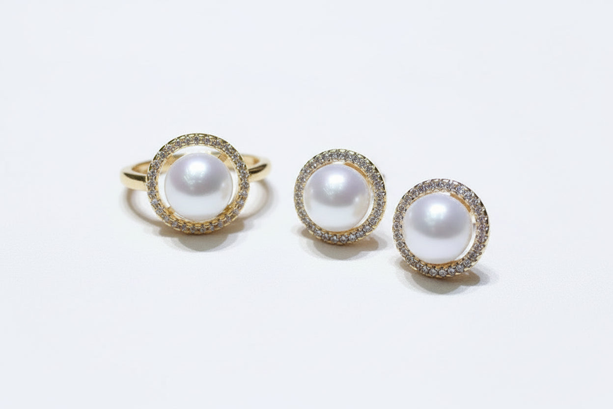 Pearl earrings with gold and diamond accents on a jewelry display box.